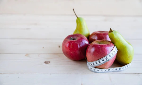 Pear and apple  on the wooden background, shape of the body