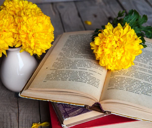 Flowers. Beautiful yellow chrysanthemum in a vintage vase. Cup of coffee. Bright Servais, cup and saucer .. Beautiful breakfast.Old books on a wooden background.
