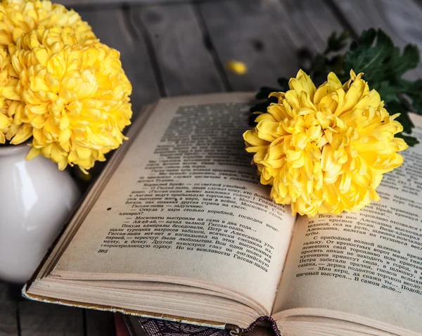 Flowers. Beautiful yellow chrysanthemum in a vintage vase. Cup of coffee. Bright Servais, cup and saucer .. Beautiful breakfast.Old books on a wooden background.