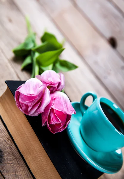 Cup of coffee on book with flowers.