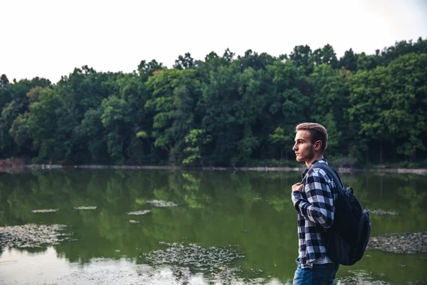 Young Man standing alone outdoor Travel Lifestyle concept with lake