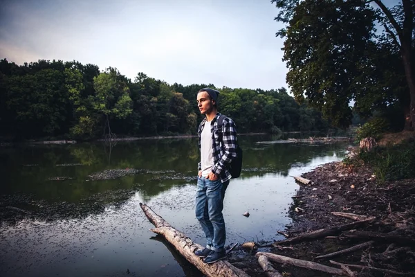 Young Man standing alone outdoor Travel Lifestyle concept with lake