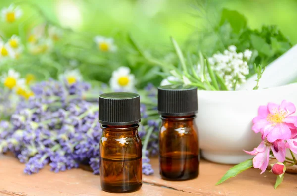 Essential oils with herbs in garden spa