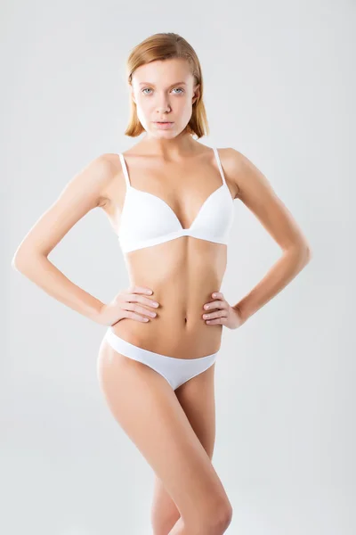 Young woman with beautiful slim body in white sport clothes - isolated