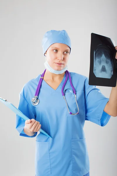 Young doctor otolaryngologist looks at a picture of the nose