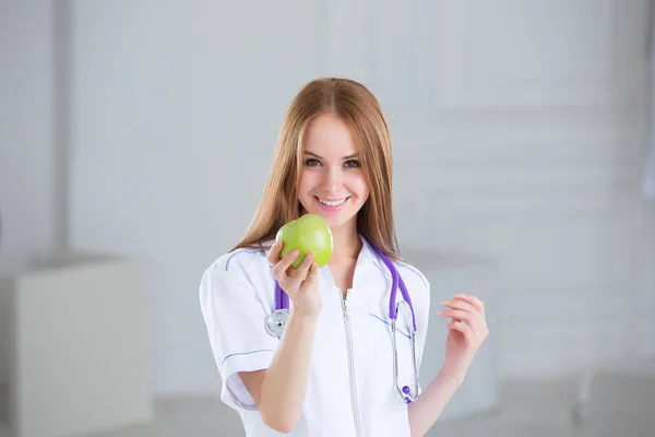 Doctor holding a green apple. Concept of healthy food.