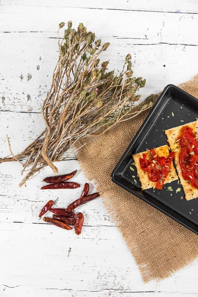 Cracker with roasted peppers, chili pepper and oregano