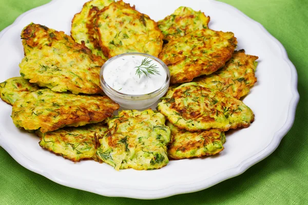 Zucchini Pancakes With  Sour Cream in White Plate