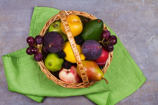 Figs, lemon, lime, plums, grape, blackberries, avocado, apples, pears and peaches in basket