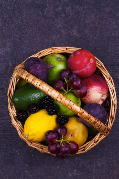 Figs, lemon, lime, plums, grape, blackberries, avocado, apples, pears and peaches in basket