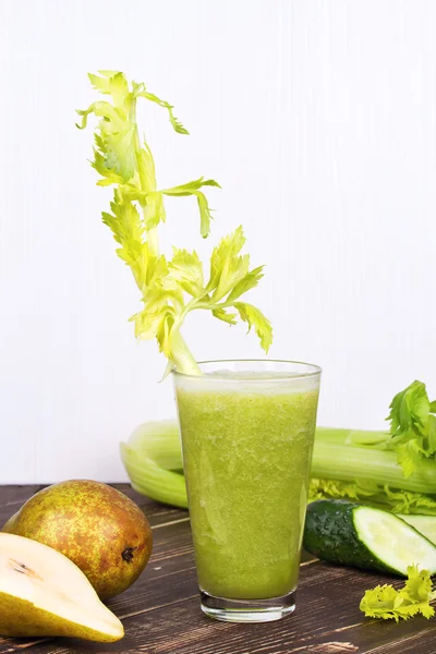 Fresh cucumber, pear and celery juice. Slices of fruits and vegetables on wooden background