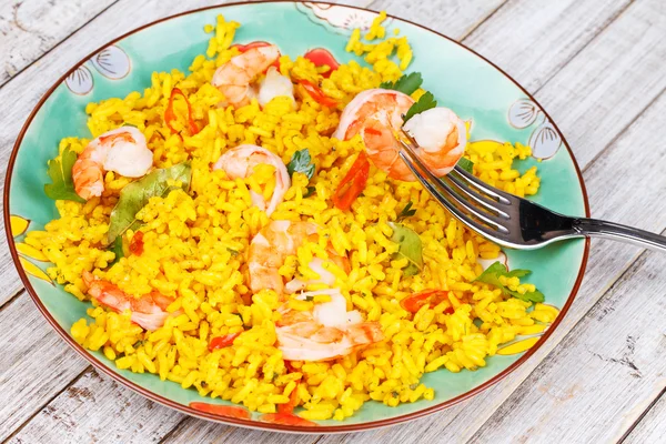 Plate of Shrimps Risotto garnished with fresh parsley and red chili pepper