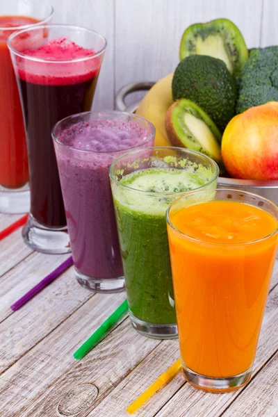 Healthy Colorful Smoothies with Fruits and Vegetables Against a Rustic Wooden Background
