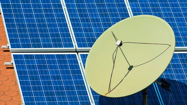 Satellite dish and solar panels on the roof of a building