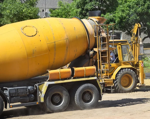 Cement mixer truck and an excavator at the construction site