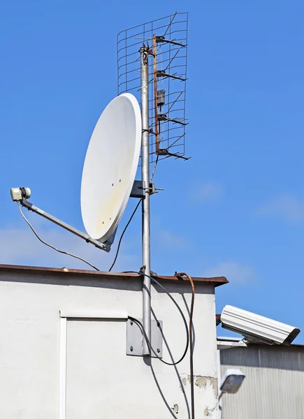 Satellite dish and security camera on the top of a building