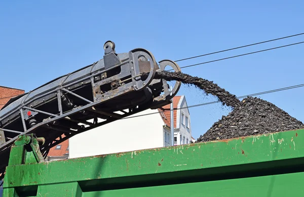 Road scraper machinery at work