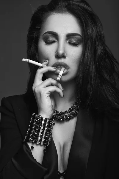 Elegant hot brunette woman smoking a cigarette