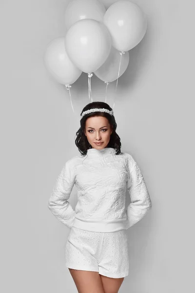 Beautiful fashion model girl with white balloons