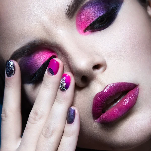 Beautiful girl with bright creative fashion makeup and colorful nail polish. Art beauty design.