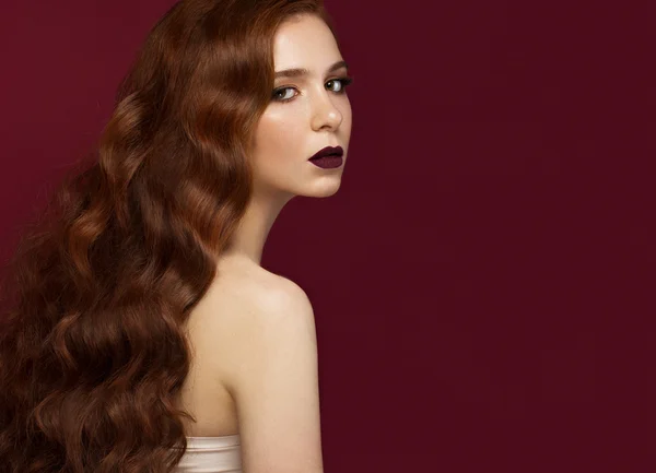 Beautiful Redhead girl with a perfectly curls hair and classic make-up. Beauty face.