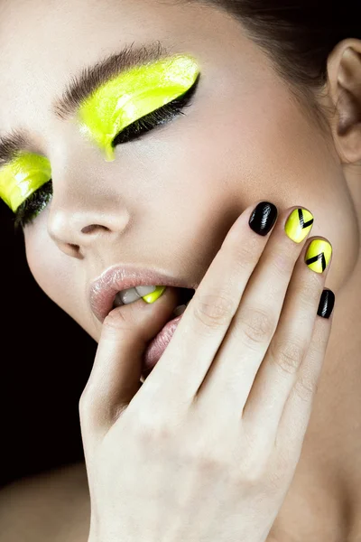 Portrait of girl with yellow and black make-up, creative nail art disign. Beauty face.