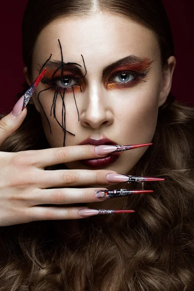 Woman in the image of spider with creative art makeup and long nails. Manicure design, beauty face.