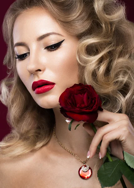 Beautiful blonde in a Hollywood manner with curls, red lips. Beauty face.