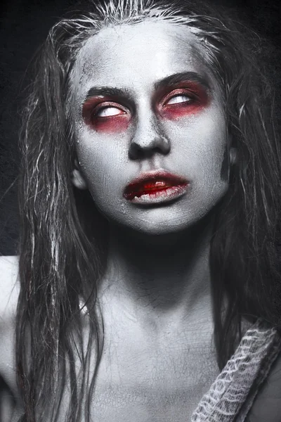 Girl in form of zombies, Halloween corpse with blood on his lips. Image for a horror film.