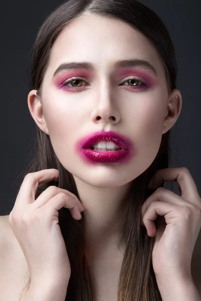 Girl with pink lipstick smeared across his face. Creative makeup.