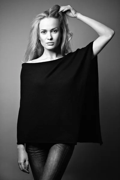Beautiful blonde girl in a shirt with a light make-up and loose hair. Model tests.