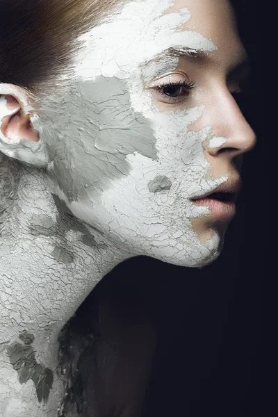 Beautiful girl with mud on his face. Cosmetic mask. Beauty face.