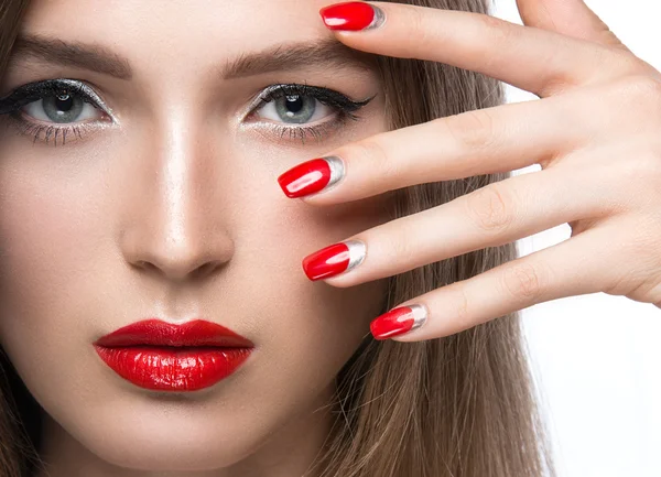 Beautiful young girl with a bright make-up and red nails. Beauty face.