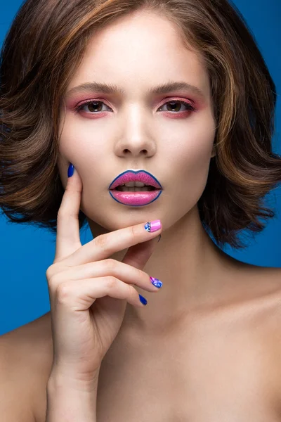 Beautiful model girl with bright makeup and colored  nail polish. Beauty face. Short colorful nails