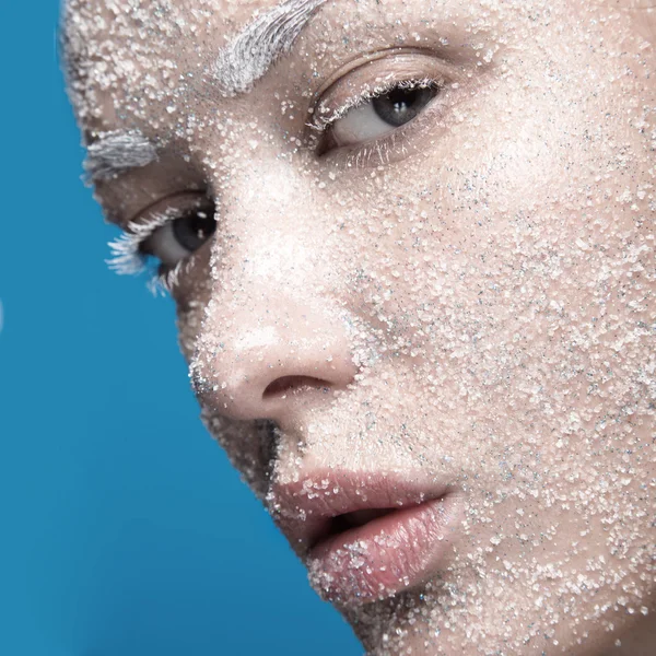 Portrait of girl with pale skin and sugar snow on her face. Creative art beauty fashion.
