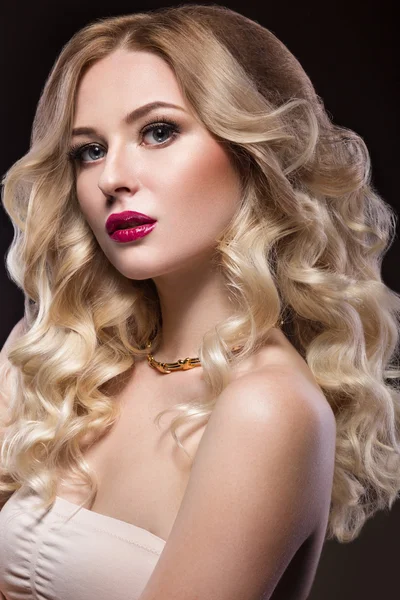 Beautiful blonde in a Hollywood manner with curls, red lips. Beauty face.