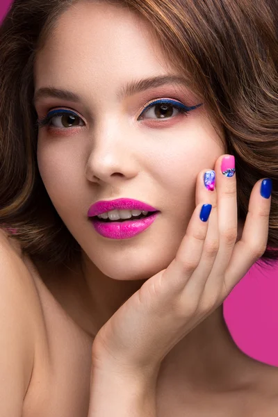 Beautiful model girl with bright pink makeup, smile and colored  nail polish. Beauty face. Short colorful nails