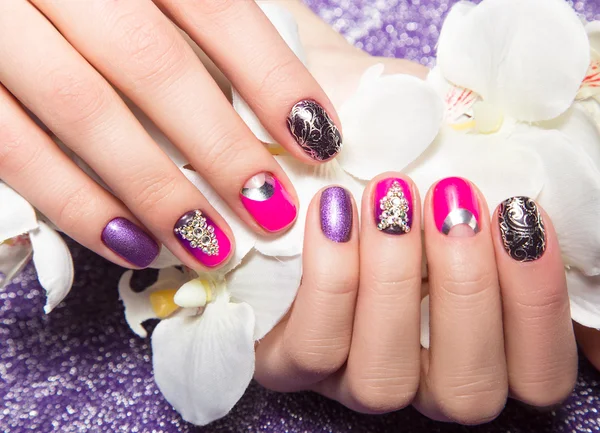 Beautiful colorful manicure with bubbles and crystals on female hand. Close-up.