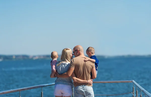 Happy family of four on jetty by the river