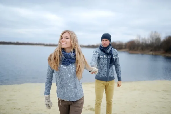The guy and the girl walk on a desert autumn beach