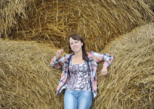 The girl in jeans in a haystack