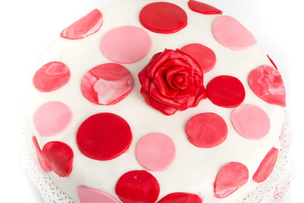 Cake decorated with red discs and rose