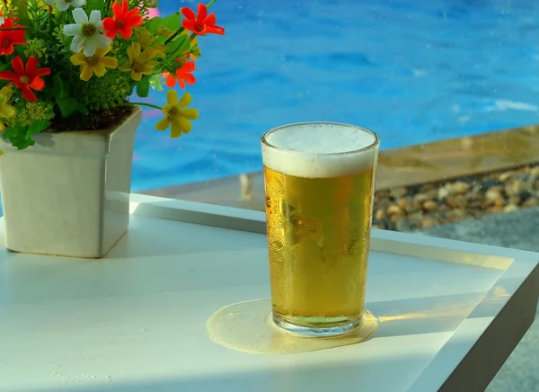 Beer mugs by swimming pool in tropical resort