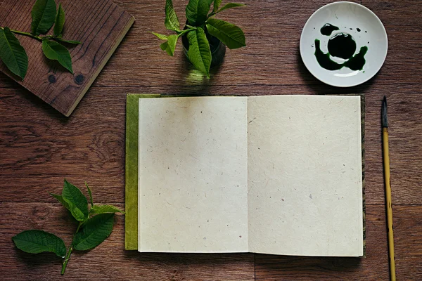 The workplace painter  and green leaves. The presentation. The blank notebook. Spring time blank notebook. Background.