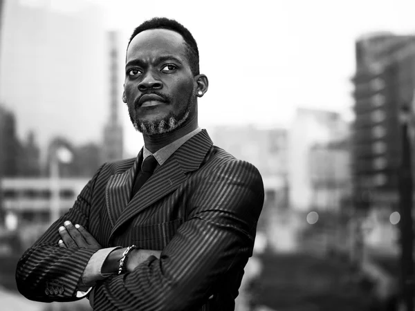 African businessman portrait with crossed arms in the city monoc