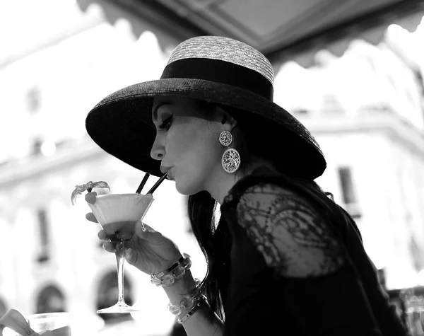 Beautiful vintage portrait of woman drinking cocktail black and
