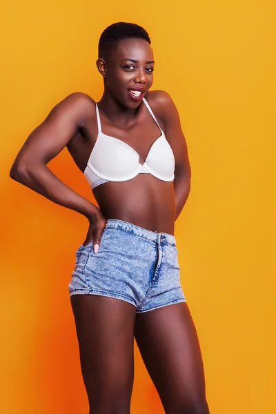 Happy african girl portrait wearing jeans shorts and bra