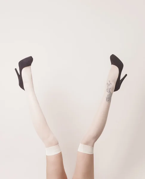 Female legs up in the air wearing stockings and heels