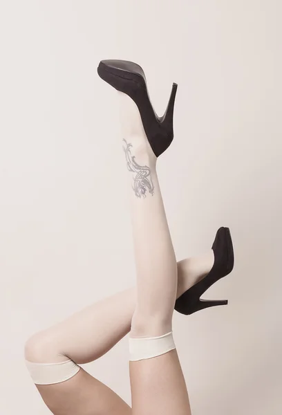 Female legs wearing parisian stockings and heels while posing