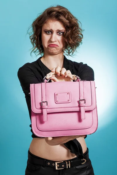 Beautiful girl holding a pink bag with disgusted look